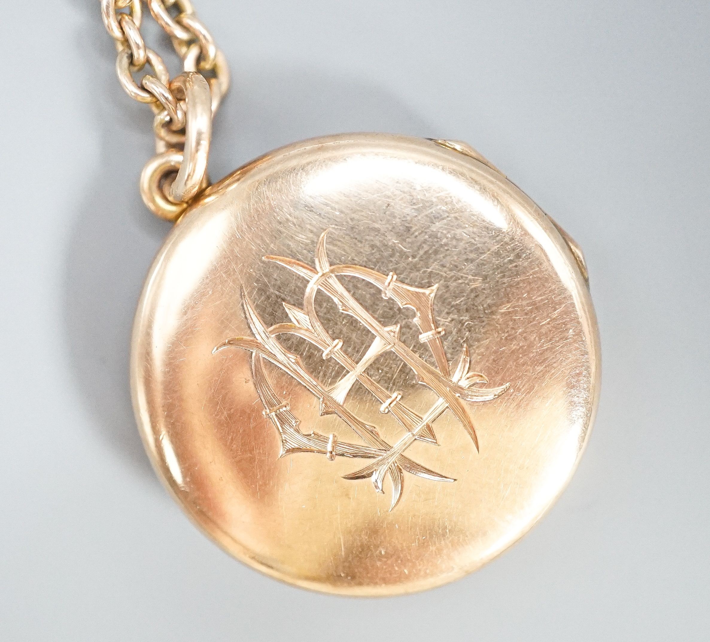 A 9ct circular locket, 26mm, on a 9k chain, 62cm, gross weight 21.2 grams.